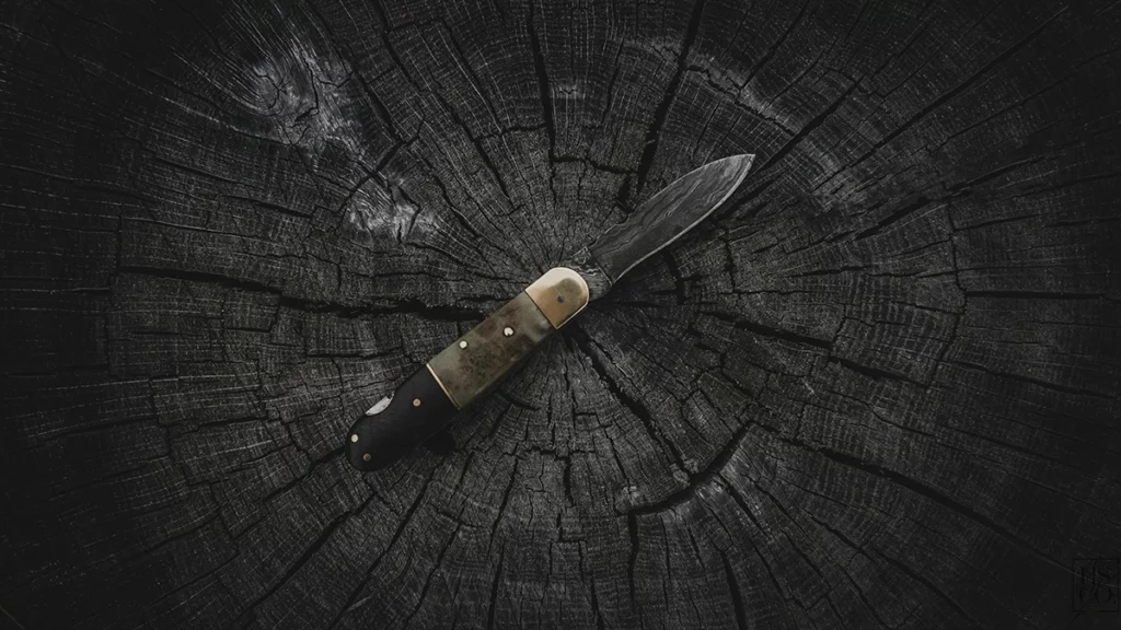 Un couteau sur un fond de bois noir